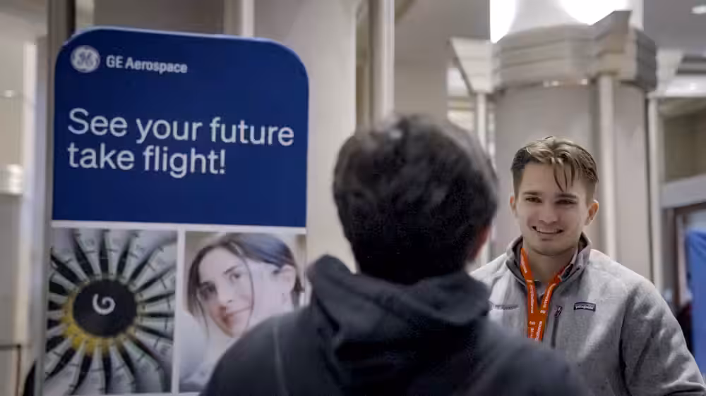 An image of a sponsor talking to a sponsor from GE Aerospace at TechOlympics 2025: Inspire.